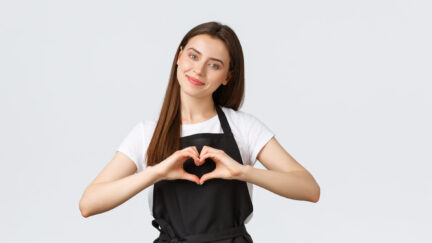 Grocery store employees, small business and coffee shops concept. Lovely friendly-looking barista inviting have taste of new drinks in cafe, showing heart sign to express love for visitors.