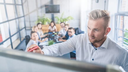Business coach. Team leader teaches employees at a business meeting in a conference room.