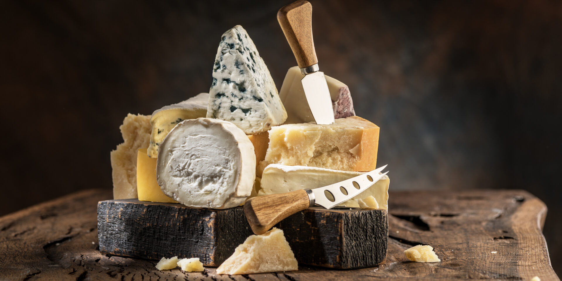 Assortment of different cheese types on wooden background. Cheese background.